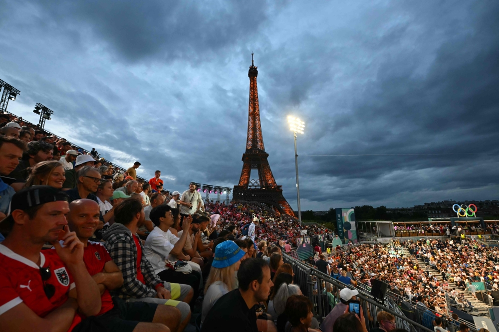 Spectators watch the men’s quarterfinal beach volleyball match between Spain and Norway during the Paris 2024 Olympic Games at the Eiffel Tower Stadium in Paris on August 7. — AFP pic